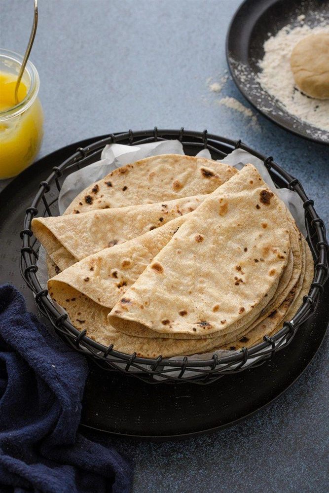 Folded whole wheat rotis in a basket